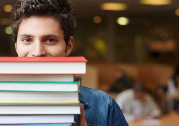 male student with stack of books